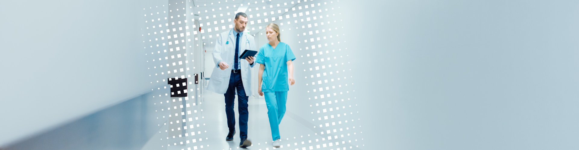 Mann und Frau in Arztkittel und Kasak im langen hellen Flur